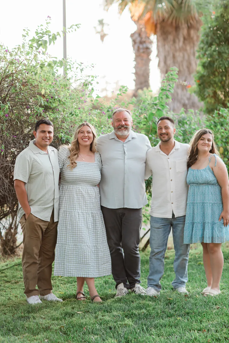 The family behind The Spot, Mitch in the middle, outdoors under the palms