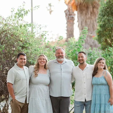 The family behind The Spot, outdoors under the palms